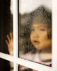 Child looking through a foggy window