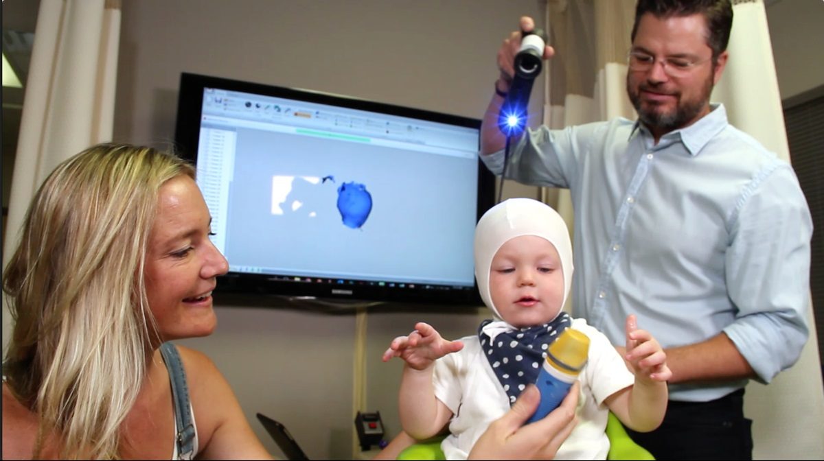 Jason Goodnough 3D-scans baby Alfred's head while mother Rebecca looks on.