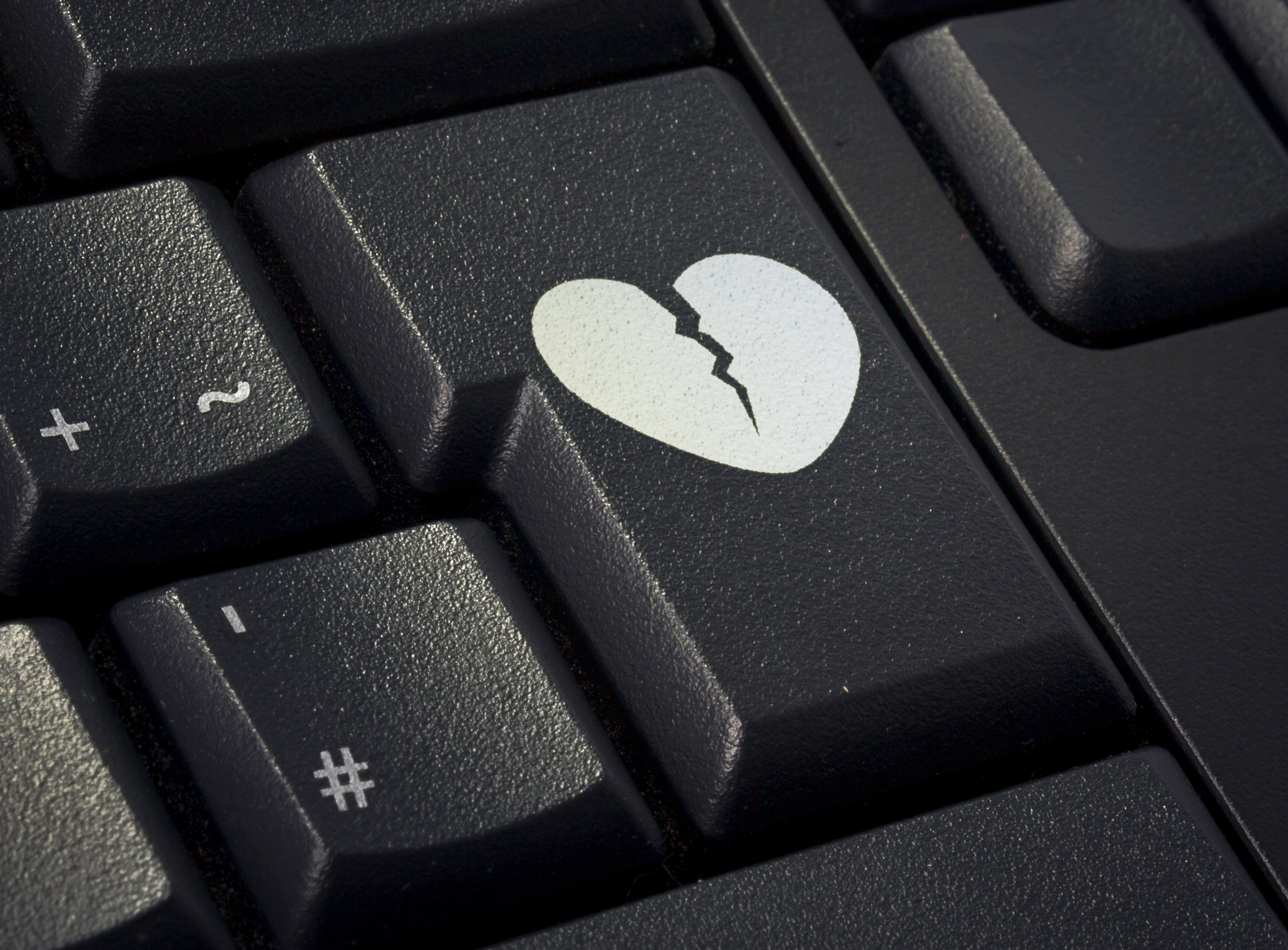 Return key of a black keyboard with the shape of a broken heart imprinted