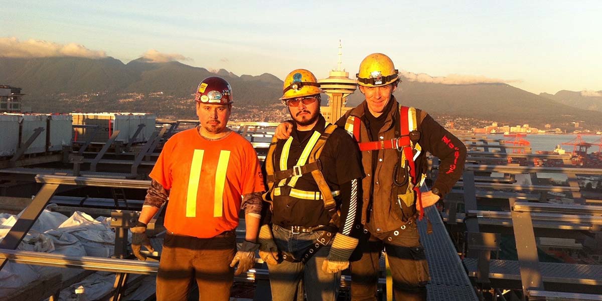 BCIT Indigenous alumnus Brandon Darbyshire-Joseph stands at a job site with two co-workers