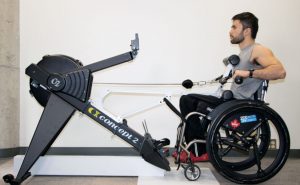 Man seated at wheelchair using a rowing ergometer