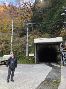 Man in hardhat standing in front of a tunnel entrance
