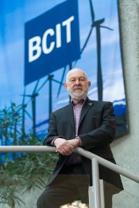 Man standing in front of large BCIT banner