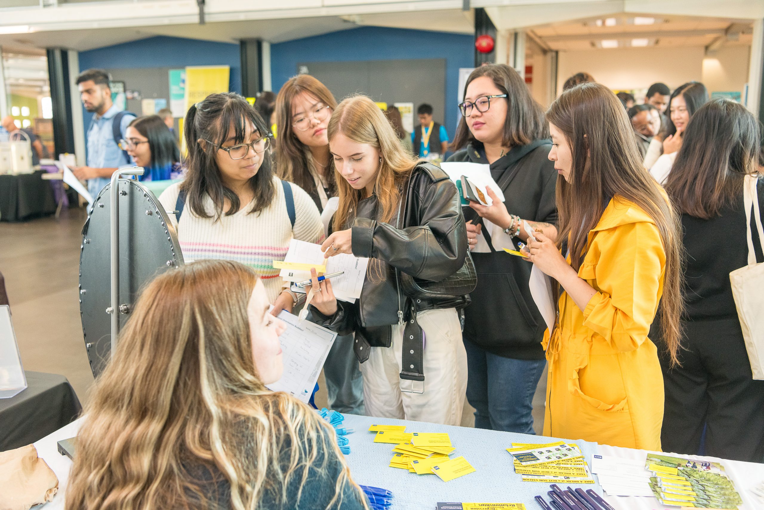 A group of students asking questions at the BCIT Student Services fair.