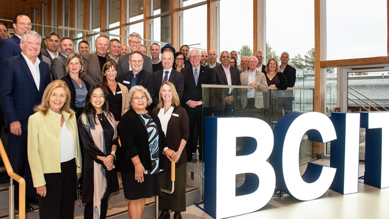 Group of donors and BCIT staff on the Health Sciences Centre stairs in front of a BCIT sign