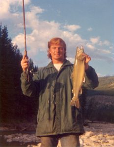 Mark Angelo holding a fishing rod and a fish in 1969