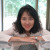 Joanna elaning on a table wit white blouse and a silver watch.